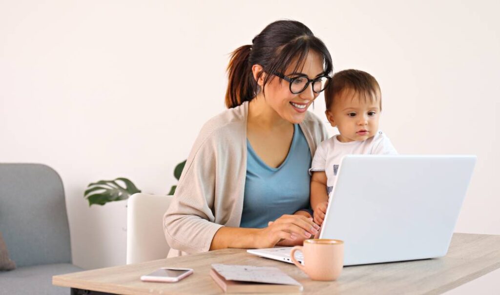 mujer trabajadora con bebe frente a una computadora