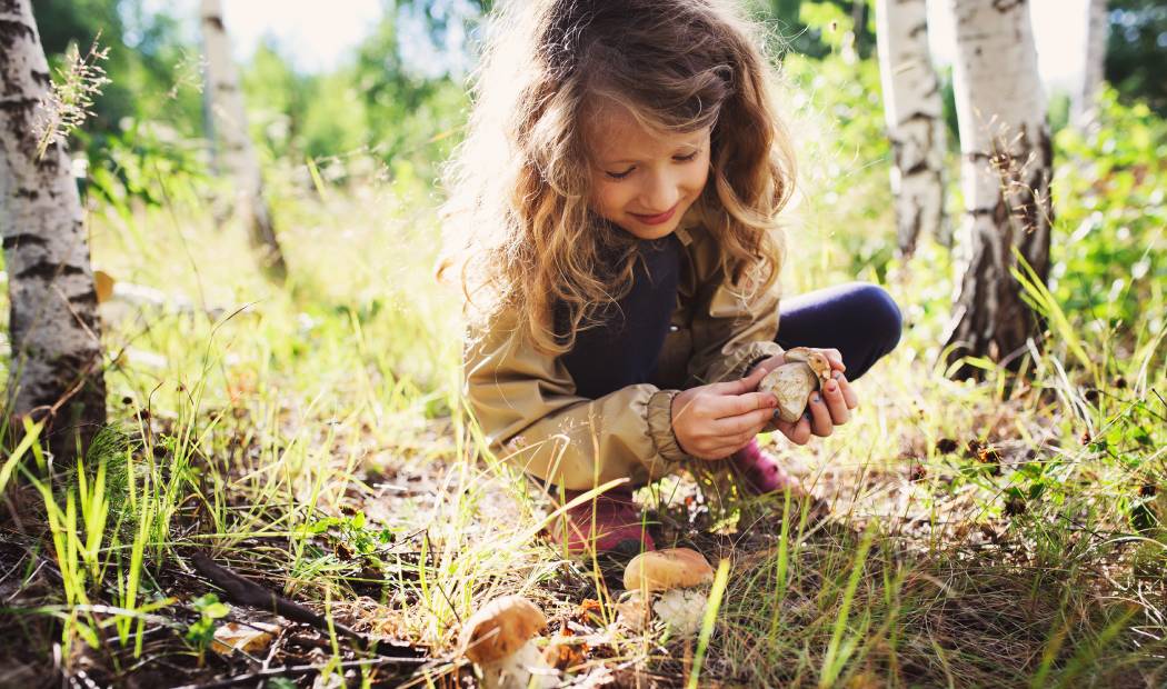niña jugando al aire libre y en contacto con la naturaleza. 